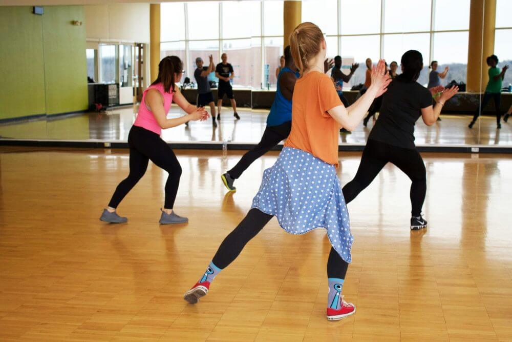 A group of people doing exercise in a dance room