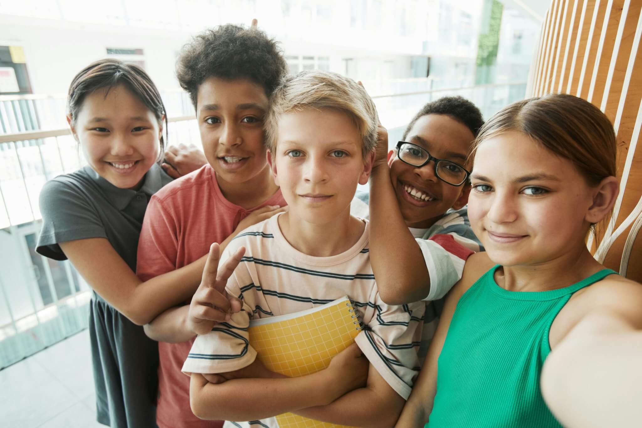 A group of tweens stand in a group and smile at the camera