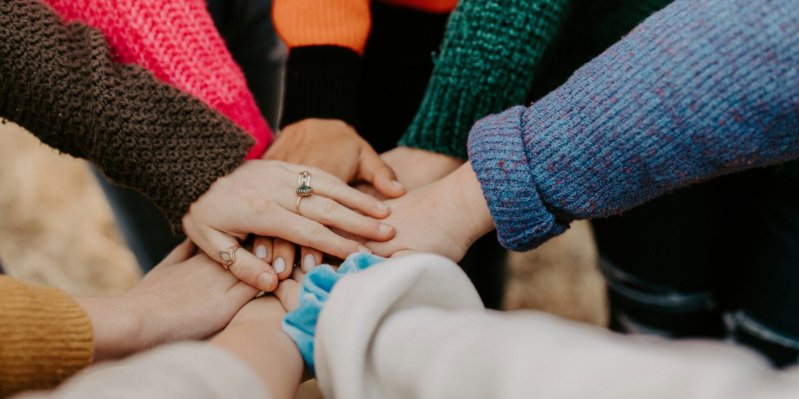 A close up of different hands all on top of each other