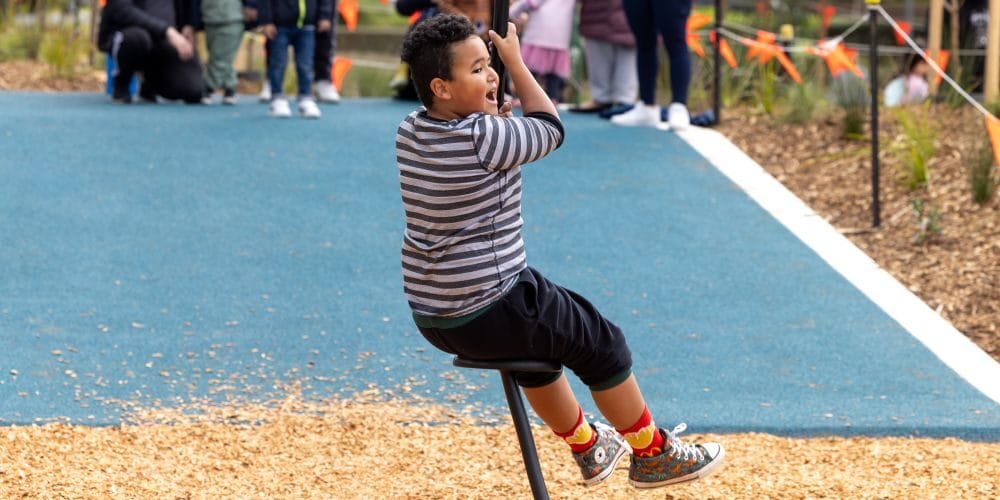 Child swinging on playground equipment